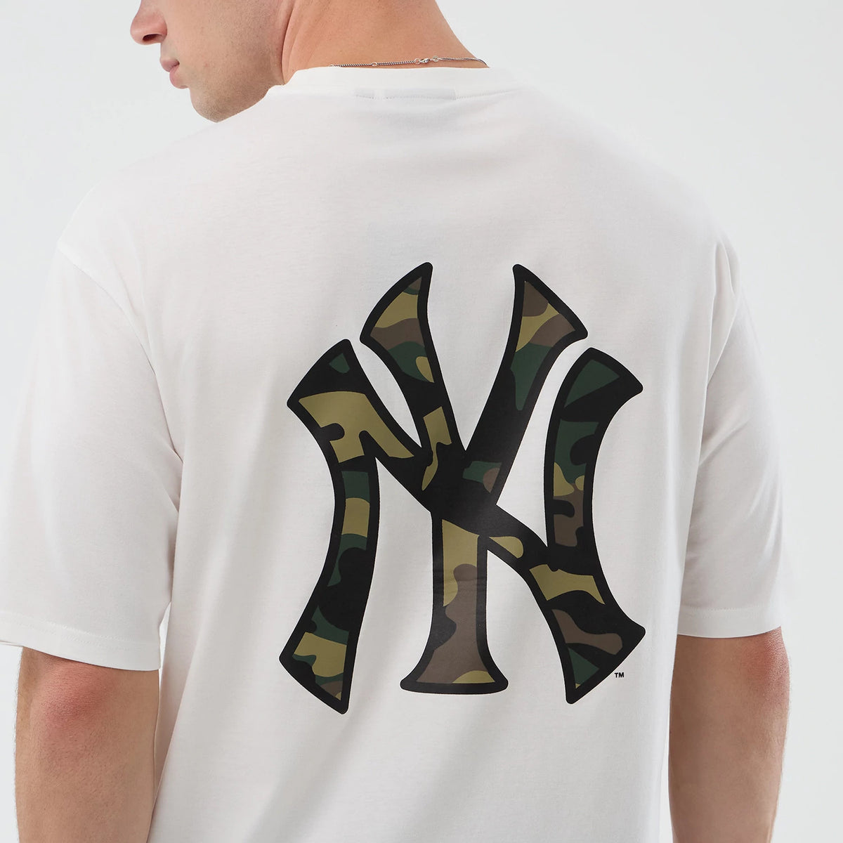New Era New York Yankees MLB Infill White Oversized T-Shirt, back view on a model featuring a oversized black New York Yankees logo with a camouflage pattern infill in the centre of the upper back on a crisp white fabric.