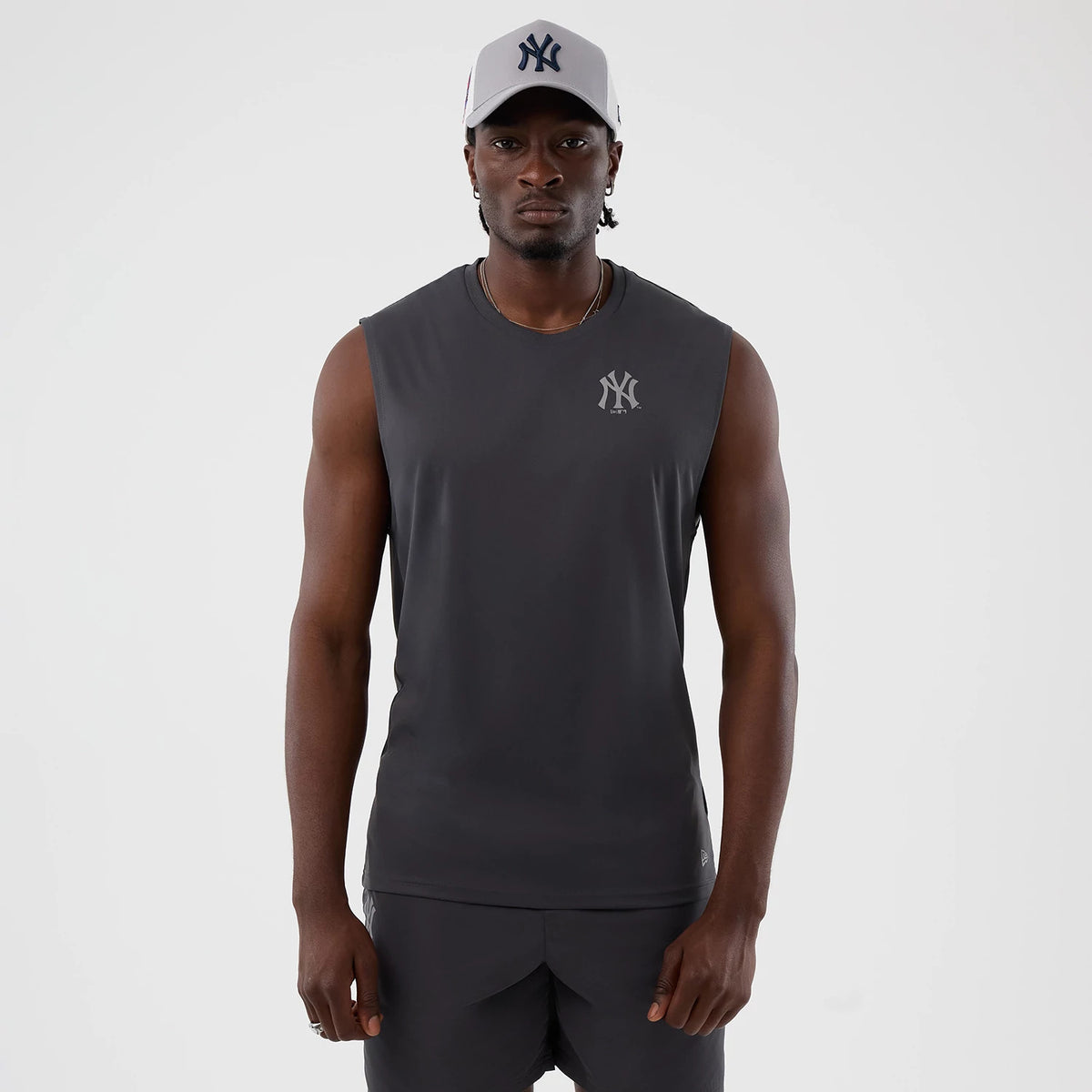 New Era New York Yankees MLB Core Plus Dark Grey Vest, front view on a model with a grey sleeveless design, featuring a New York Yankees logo in a darker shade on the chest and a matching dark colour scheme throughout.