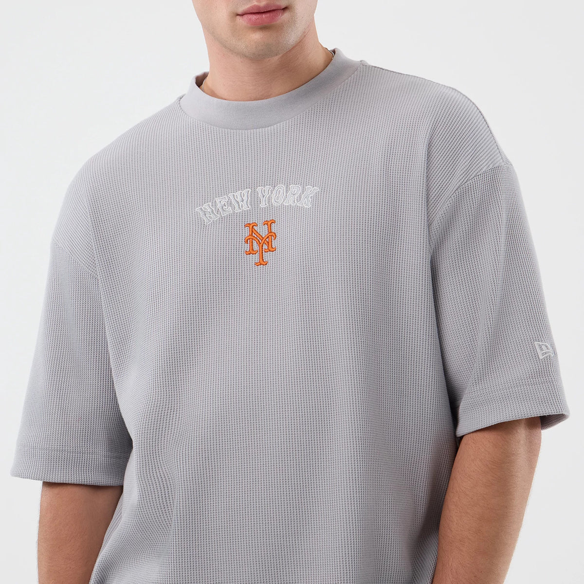 New Era New York Mets MLB Waffle Grey T-Shirt, front view showing a textured grey fabric with white embroidered NEW YORK lettering and an orange Mets logo on the chest, embroidered New Era logo on the left sleeve.