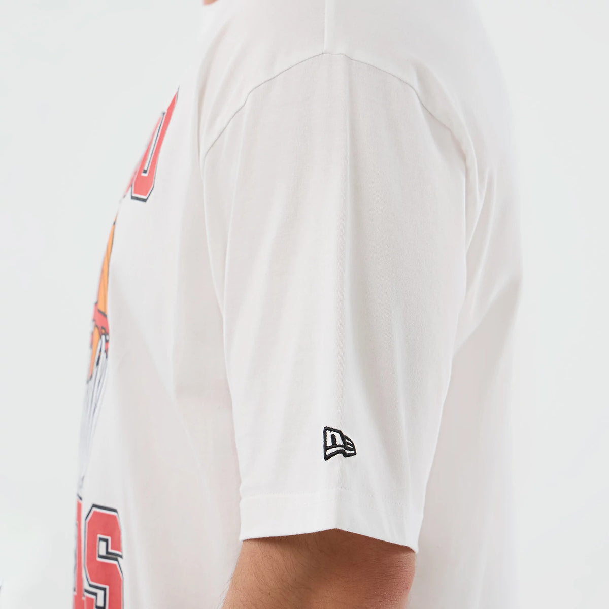 New Era Chicago Bulls NBA Basketball Graphic White Oversized T-Shirt, side view showing the short sleeve with a small black embroidered New Era logo near the hem, and a glimpse of the front graphic extending from the chest.