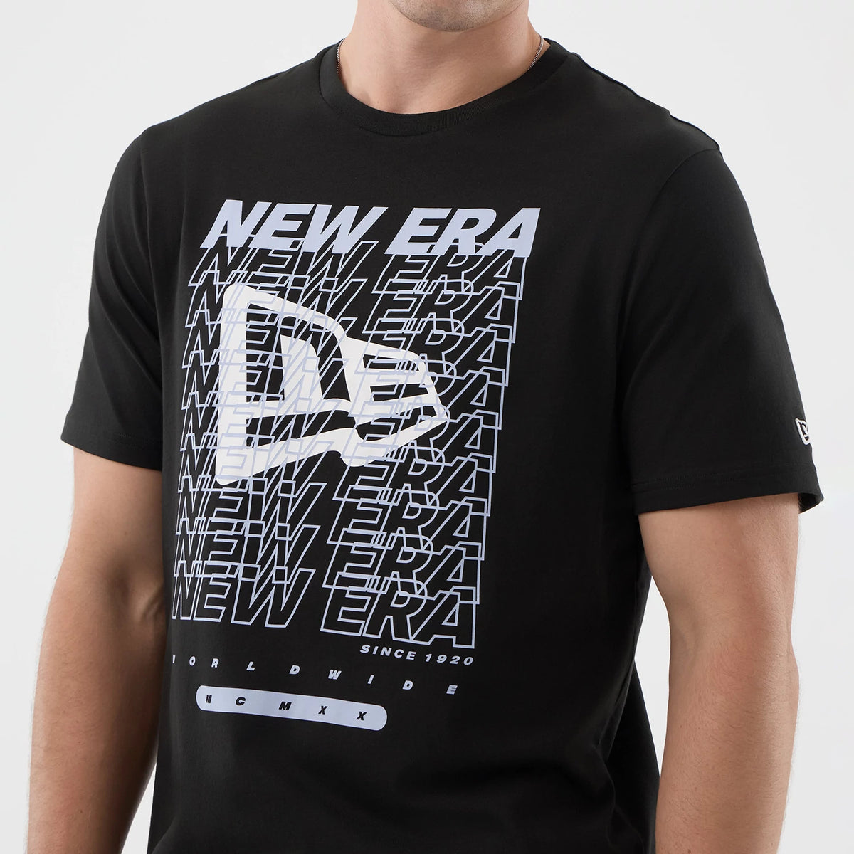 New Era Logo Graphic Black T-Shirt, front view showing a prominent white printed graphic with multiple New Era text overlays across the chest, a large New Era logo in the centre, and a small embroidered logo on the left sleeve.