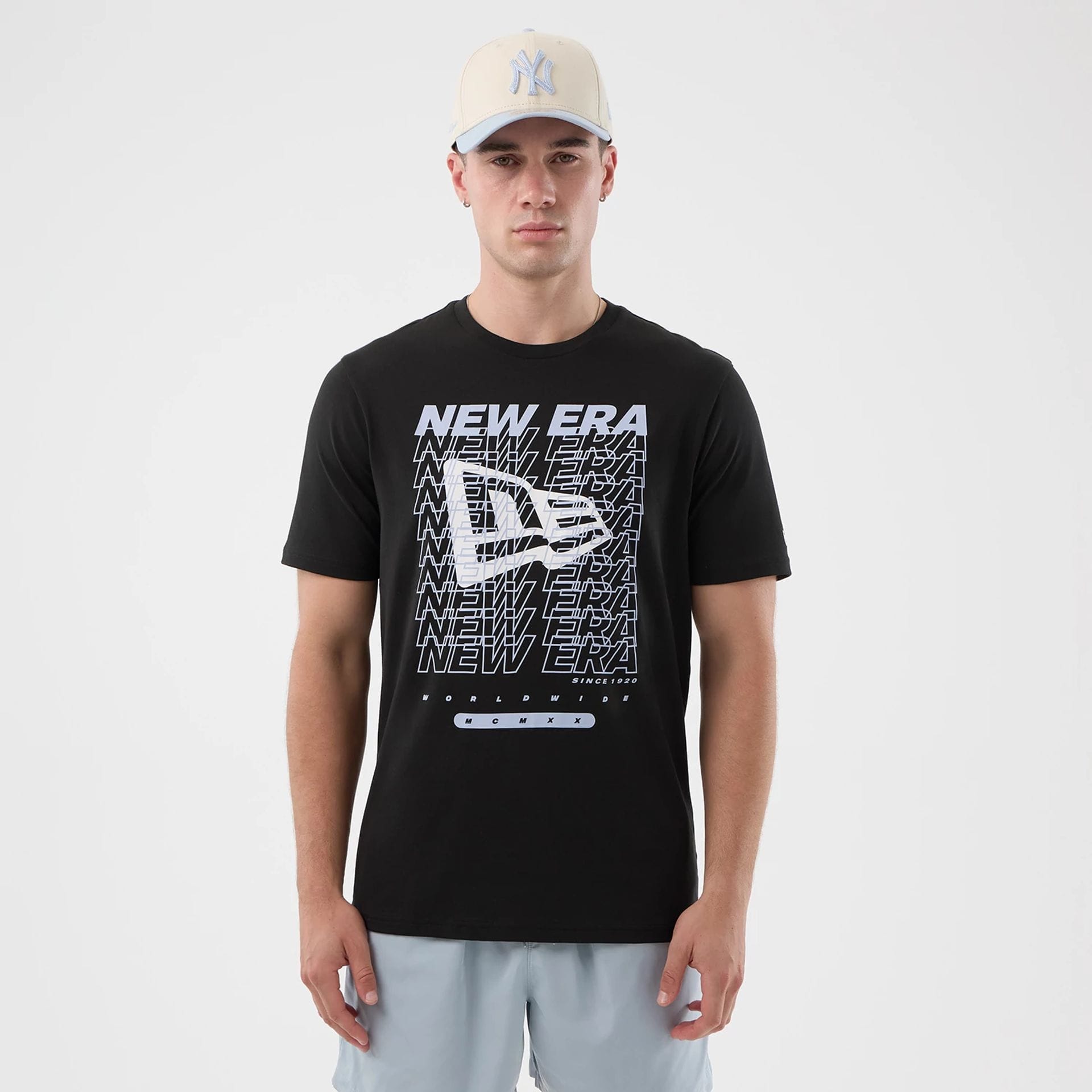 The model is wearing this New Era Logo Graphic T-Shirt in black. 1