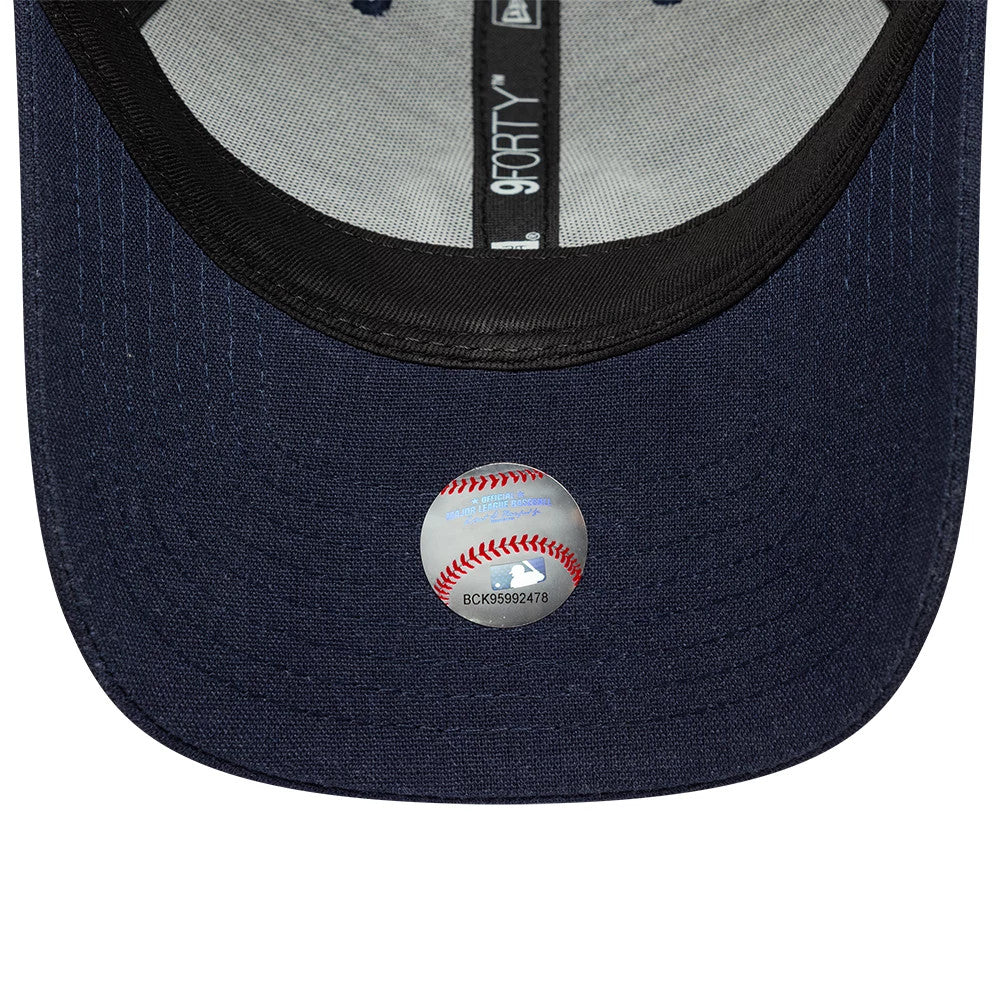 New York Yankees MLB Linen Navy New Era 9FORTY M-Crown Adjustable Cap, inside view showing the dark sweatband and grey panel taping marked with 9FORTY branding, along with a sticker resembling a baseball on the navy undervisor.