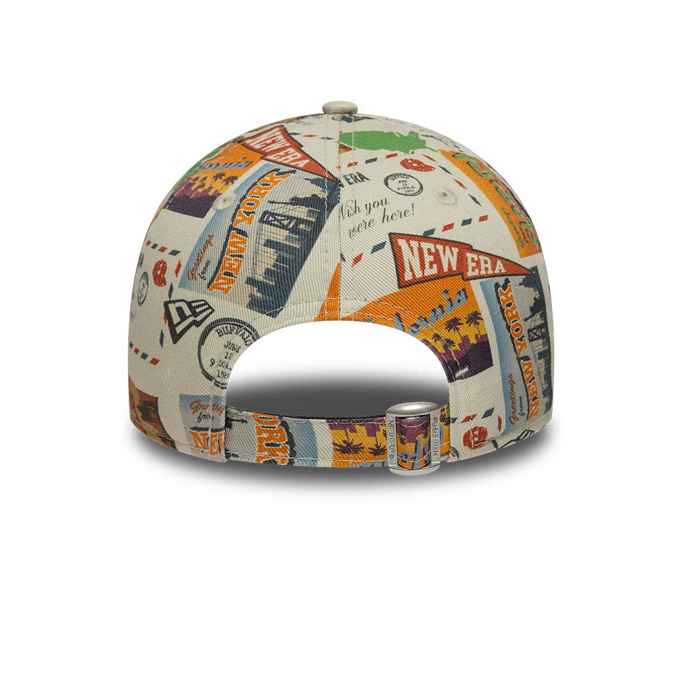 Youth New Era Location Light Beige 9FORTY Adjustable Cap, rear view showing a multicoloured travel print with postcards and stamps, featuring the New Era logo on the mid-panel, and an adjustable strap with a buckle at the back.