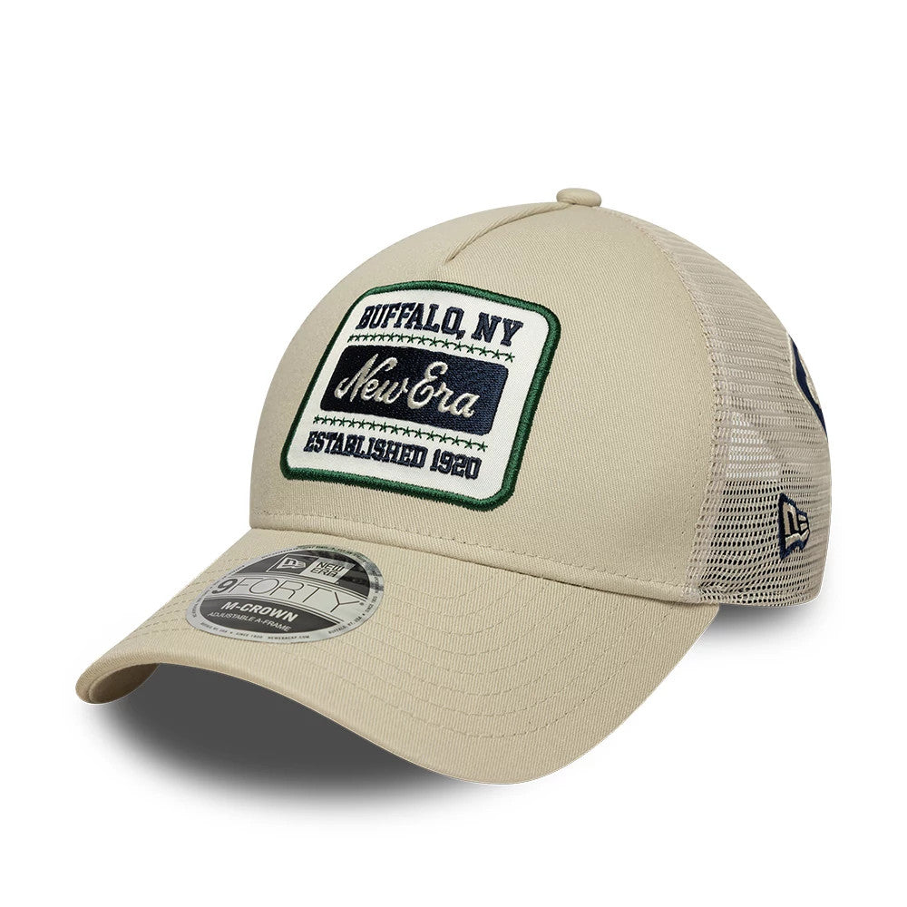 New Era Multi Patch Cream New Era 9FORTY M-Crown A-Frame Adjustable Cap, three-quarter view showing a green-bordered embroidered patch on the front panel, a cream curved visor with a 9FORTY size sticker.