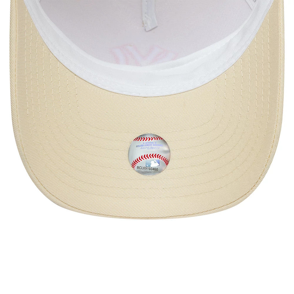 New York Yankees MLB Outline Cream New Era 9FORTY E-Frame Trucker Adjustable Cap, inside view showing the white sweatband and cream undervisor with an MLB baseball design sticker at the centre, highlighting the structured panels.