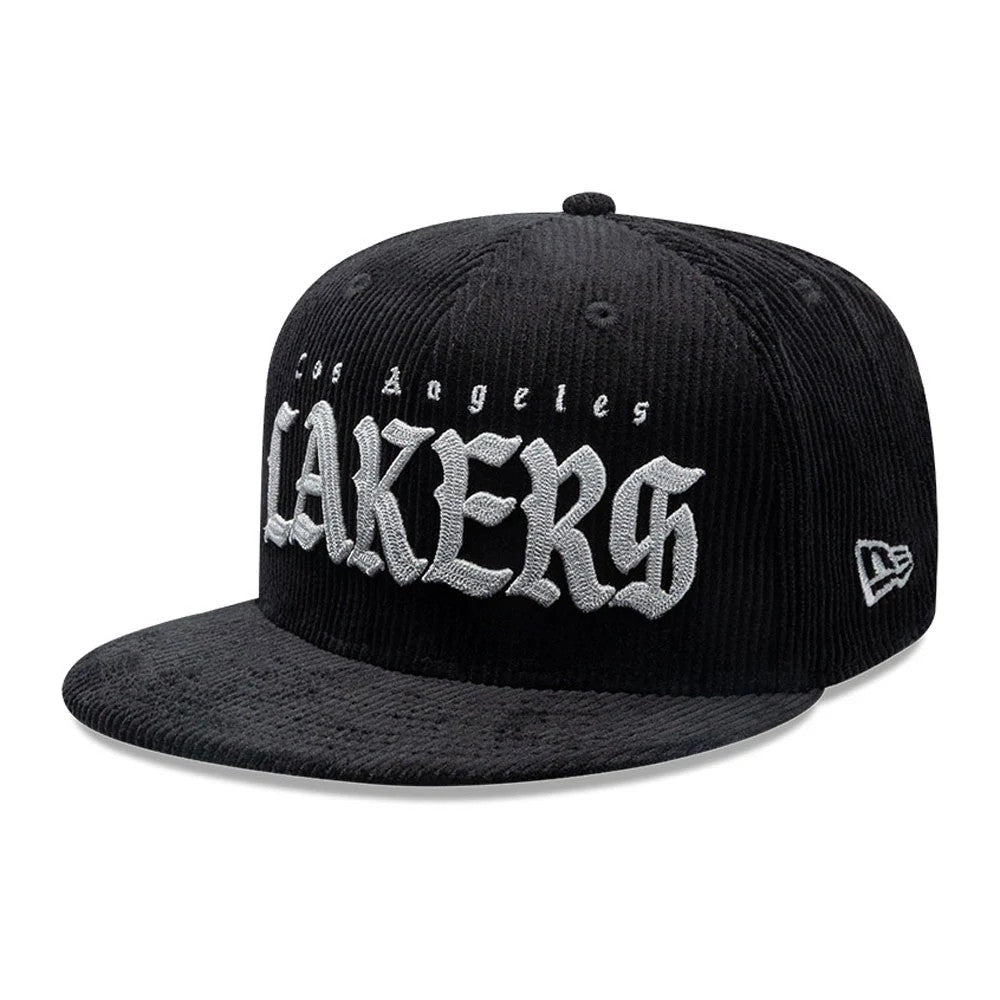 LA Lakers NBA Old English Black New Era 9FIFTY Snapback Cap, three-quarter view showing grey embroidered Old English style Los Angeles Lakers lettering on the front panel, with a black corduroy visor and New Era flag logo on the left side.