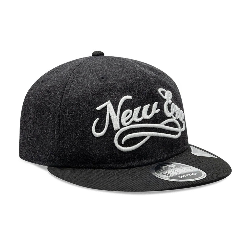 New Era Melton Wool Black Retro Crown 9FIFTY Cap, three-quarter view showing the large white raised embroidered script logo on the front panel, black flat visor with a 9FIFTY size sticker, and a matching black top button.