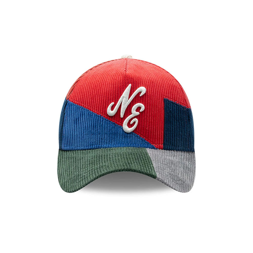 New Era Patchwork Red 9FORTY A-Frame Cap, front view showing a white embroidered NE logo on the red and blue patchwork front panels, with a green and grey corduroy visor and a top button.