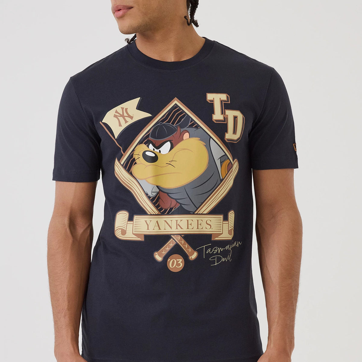 New Era New York Yankees MLB X Looney Tunes Navy T-Shirt, front view featuring a graphic of Tasmanian Devil inside a diamond shape with bats and Yankees text, an embroidered New Era logo on the sleeve, and TD lettering on the chest.