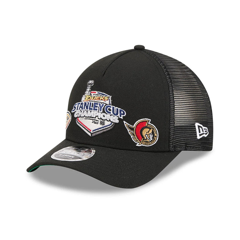 Ducks NHL Stanley Cup Black New Era 9FORTY M-Crown A-Frame Trucker Adjustable Cap, front view showing the embroidered Stanley Cup Champions logo on the structured front panel, with additional team patches.