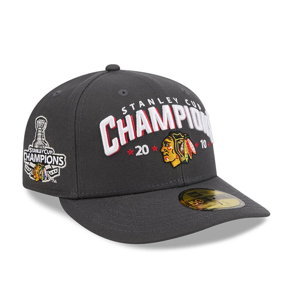 Chicago Blackhawks NHL Stanley Cup Champions Dark Grey New Era 59FIFTY Fitted Cap, three-quarter view showing raised white and red embroidered CHAMPIONS lettering on the front, Chicago Blackhawks logo beside it.