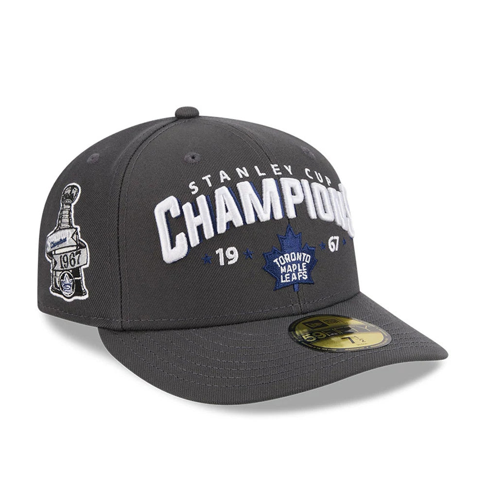 Toronto Maple Leafs NHL Stanley Cup Champions Dark Grey New Era 59FIFTY Fitted Cap, three-quarter view showing large white and blue embroidered CHAMPIONS lettering on the front, a side patch of the Stanley Cup.