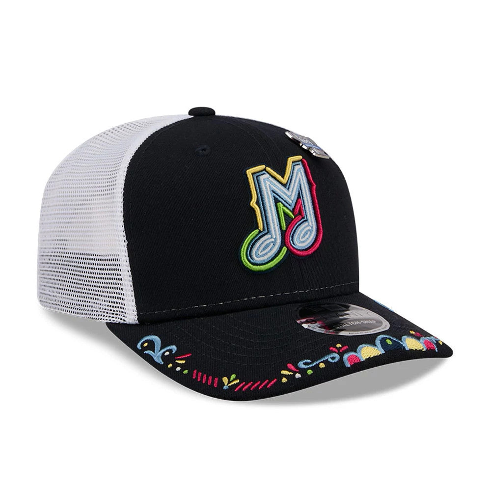 Memphis Redbirds MiLB La Copa 2026 Navy New Era 9SEVENTY Stretch Snap Adjustable Cap, front view showing the colourful embroidered M logo on the front panel with a multicoloured pattern on the black curved visor and 9SEVENTY size sticker on top.