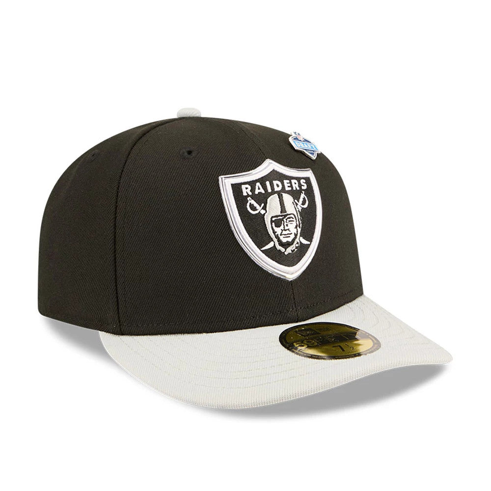 Las Vegas Raiders NFL Draft 2026 Black New Era 59FIFTY Fitted Cap, three-quarter view showing the white embroidered Raiders shield logo on the front panel, a contrasting light grey visor with a gold 59FIFTY size sticker, and a draft pin on the crown.