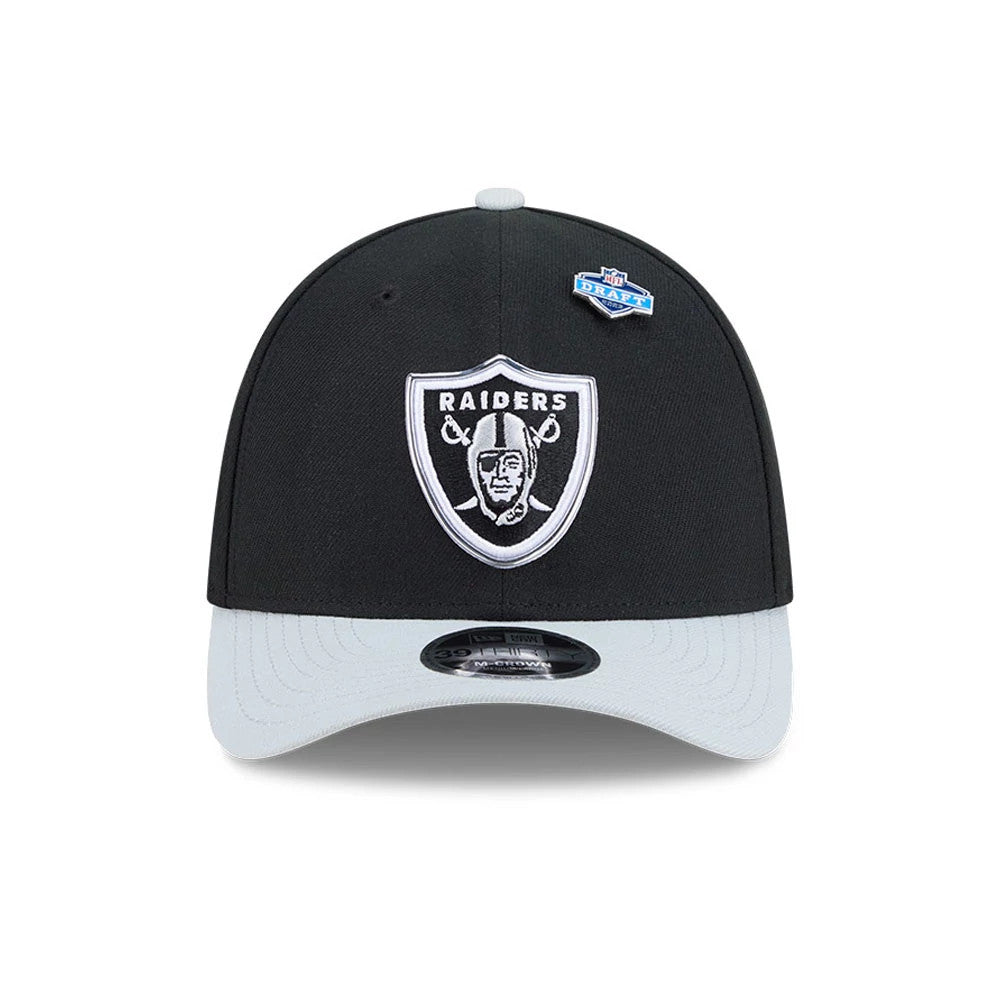 Raiders NFL Draft 2026 Black New Era 39THIRTY M-Crown Stretch Fit Cap, front view showing a white embroidered Raiders logo on the black crown with a contrasting grey curved visor, featuring a 39THIRTY size sticker and an NFL Draft patch on the side.