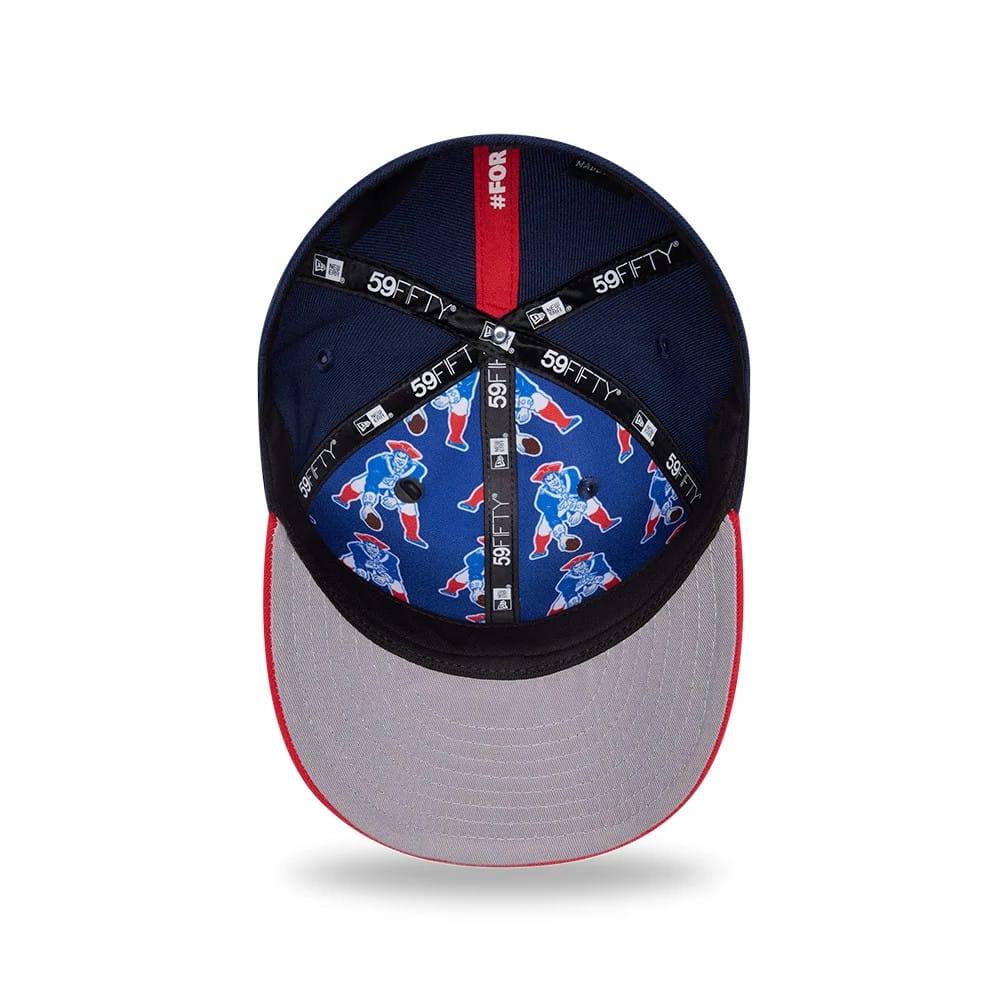 New England Patriots NFL Draft 2026 Dark Blue New Era 59FIFTY Fitted Cap, inside view showing the blue fabric lining with a repeating Pat Patriot graphic, black taping with white 59FIFTY branding, and a grey undervisor edged in red stitching.