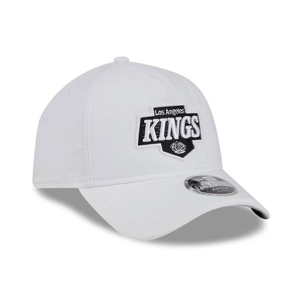 LA Kings NHL Quickstrike White New Era 9FORTY Apex Adjustable Cap, front view showing the raised black and white embroidered LA Kings logo on the front panel, a white curved visor, and the 9FORTY size sticker on the right visor corner.