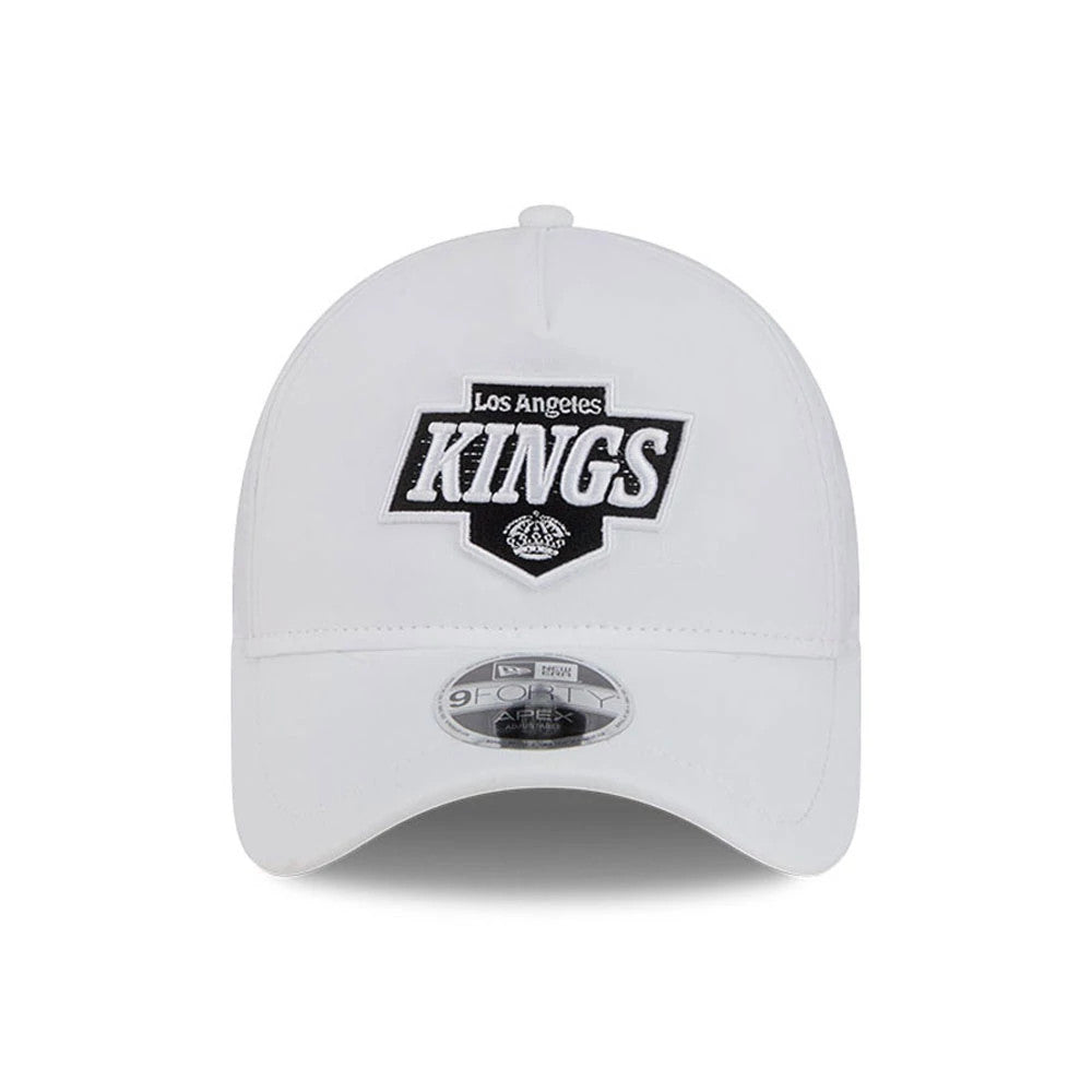 LA Kings NHL Quickstrike White New Era 9FORTY Apex Adjustable Cap, front view showing the raised embroidered Los Angeles Kings logo in black and white on the structured white crown, with a 9FORTY size sticker on the gently curved visor.