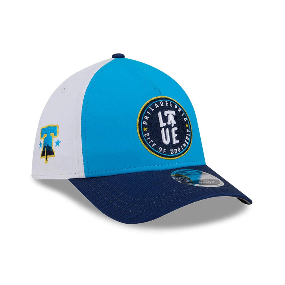 Phillies MLB City Connect Blue New Era 39THIRTY M-Crown A-Frame Stretch Fit Cap, front view showing a circular Philadelphia City of Brotherly Love logo in raised embroidery on the blue front panel, with a dark blue curved visor.