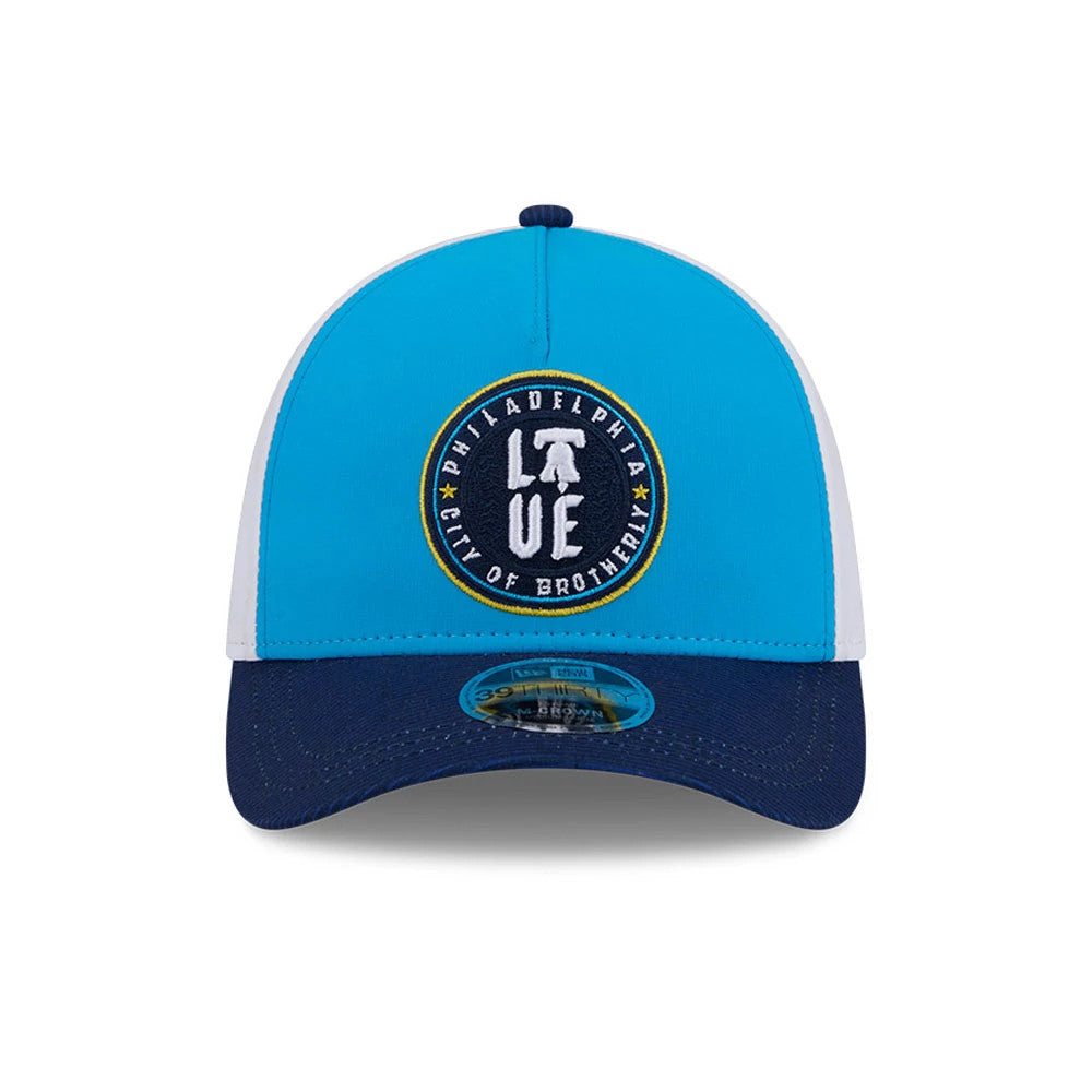 Phillies MLB City Connect Blue New Era 39THIRTY M-Crown A-Frame Stretch Fit Cap, front view showing the prominent circular Philadelphia City of Brotherly Love logo with white embroidered text on the blue panel.