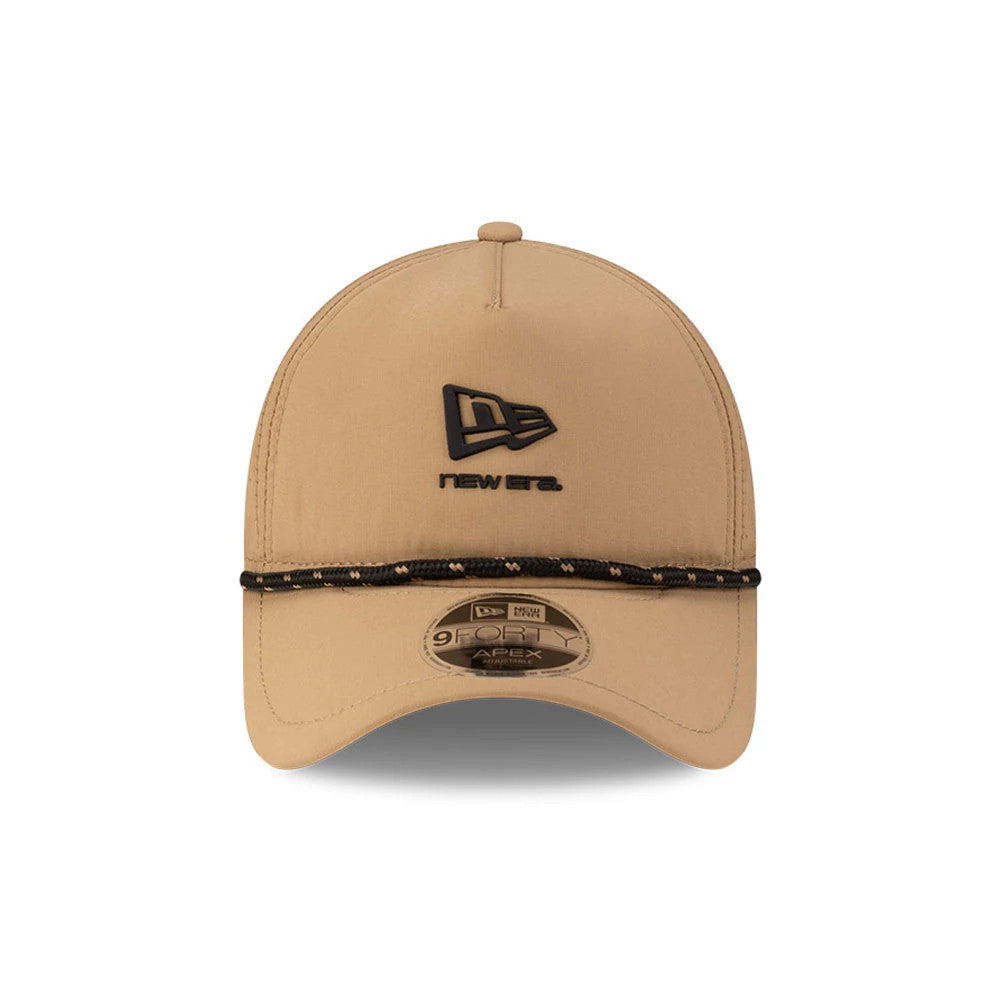 New Era Beige 9FORTY Apex Cap, front view showing the black embroidered New Era logo and text on the front panel, with a decorative black and gold cord above the visor and a 9FORTY size sticker on the beige curved visor.