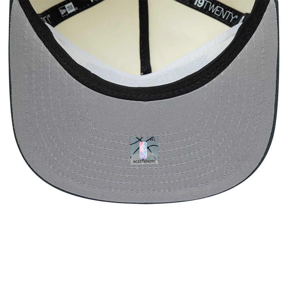 Chicago Bulls NBA Metallic Logo Cream New Era 19TWENTY Adjustable Cap, inside view showing the grey undervisor with an NBA holographic sticker, black internal taping with white logos, and cream sweatband bordering the interior edge.