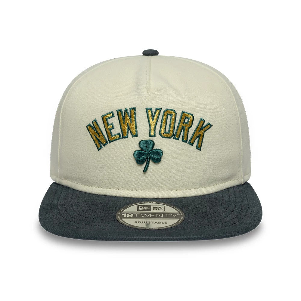 New York Yankees MLB Metallic Logo Cream New Era 19TWENTY Adjustable Cap, front view showing green and gold embroidered New York lettering above a green shamrock, a dark grey visor, and the 19TWENTY size sticker on the flat visor.