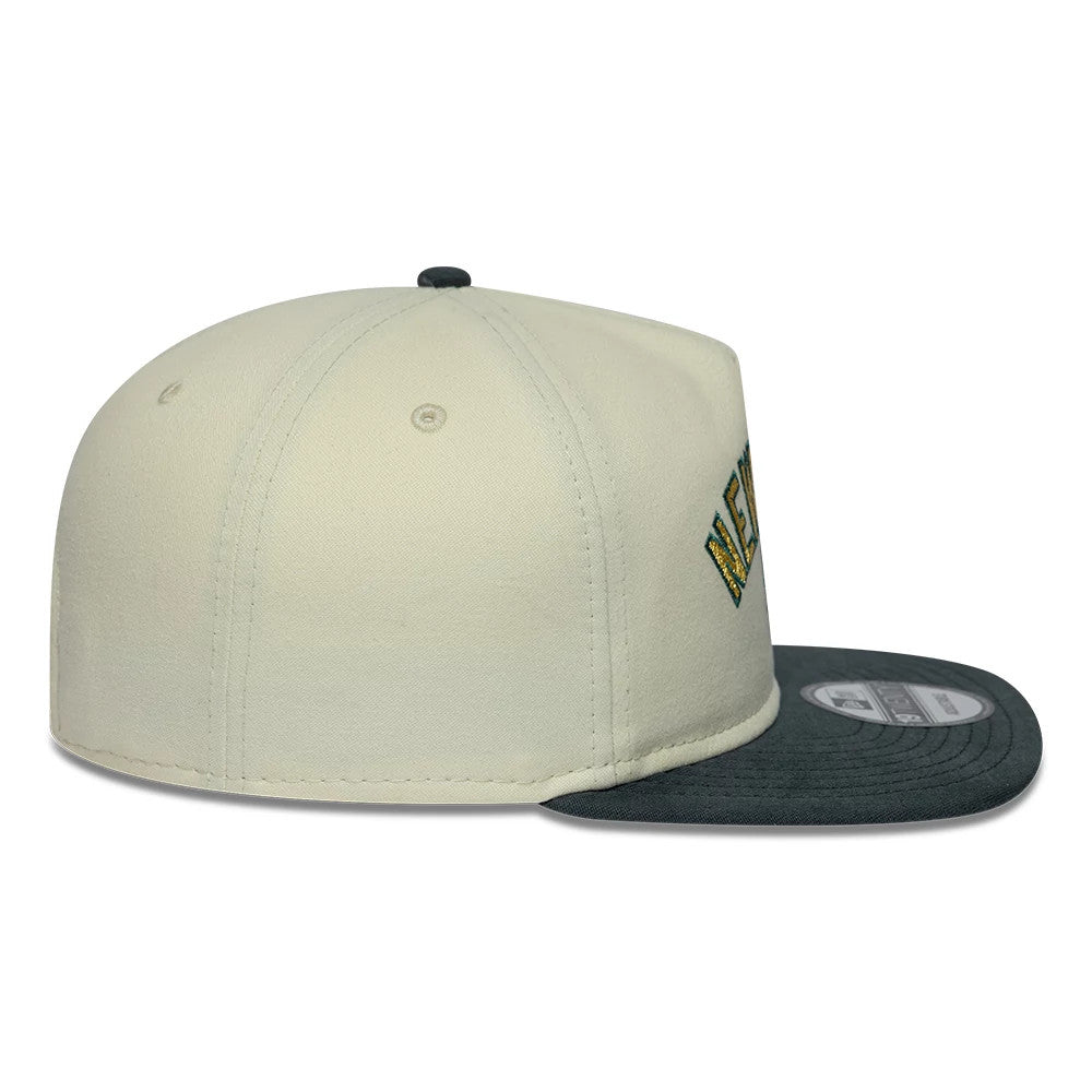 New York Yankees MLB Metallic Logo Cream New Era 19TWENTY Adjustable Cap, side view showing the raised New York Yankees lettering on the cream crown, with a dark grey flat visor and a New Era flag logo on the left side.