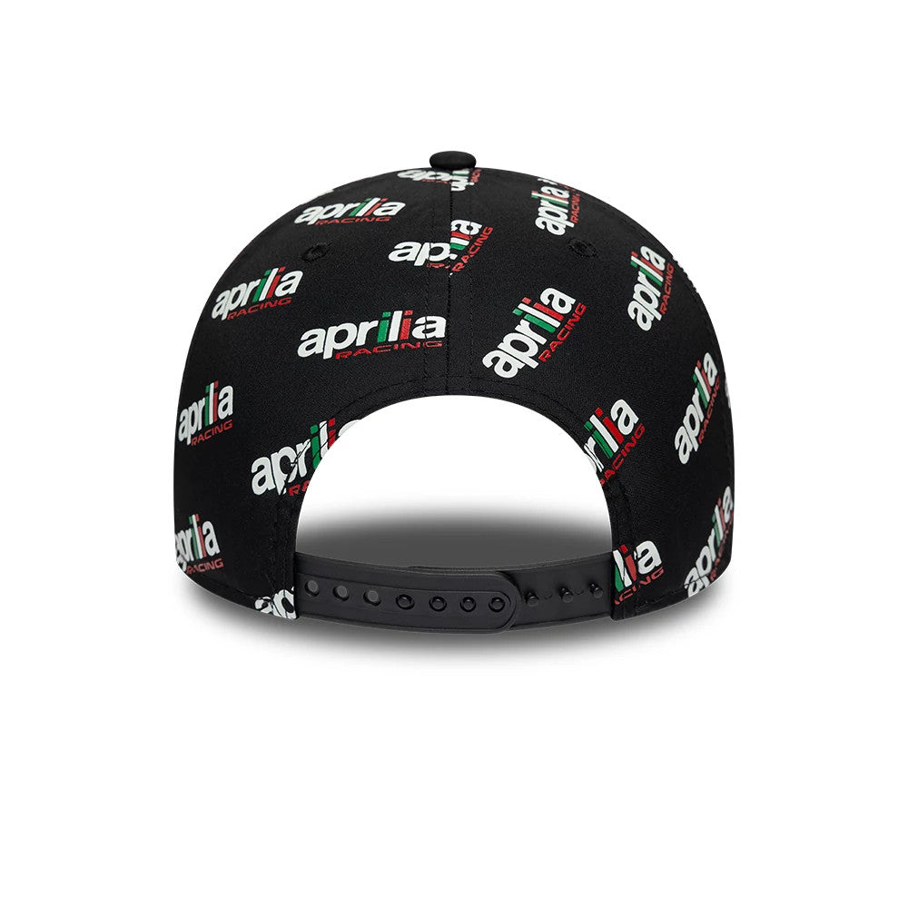 Aprilia All Over Print Black New Era 9FORTY Adjustable Cap, rear view showing multiple Aprilia Racing logos in white, red, and green printed across the black structured crown, with a black adjustable strap at the back.