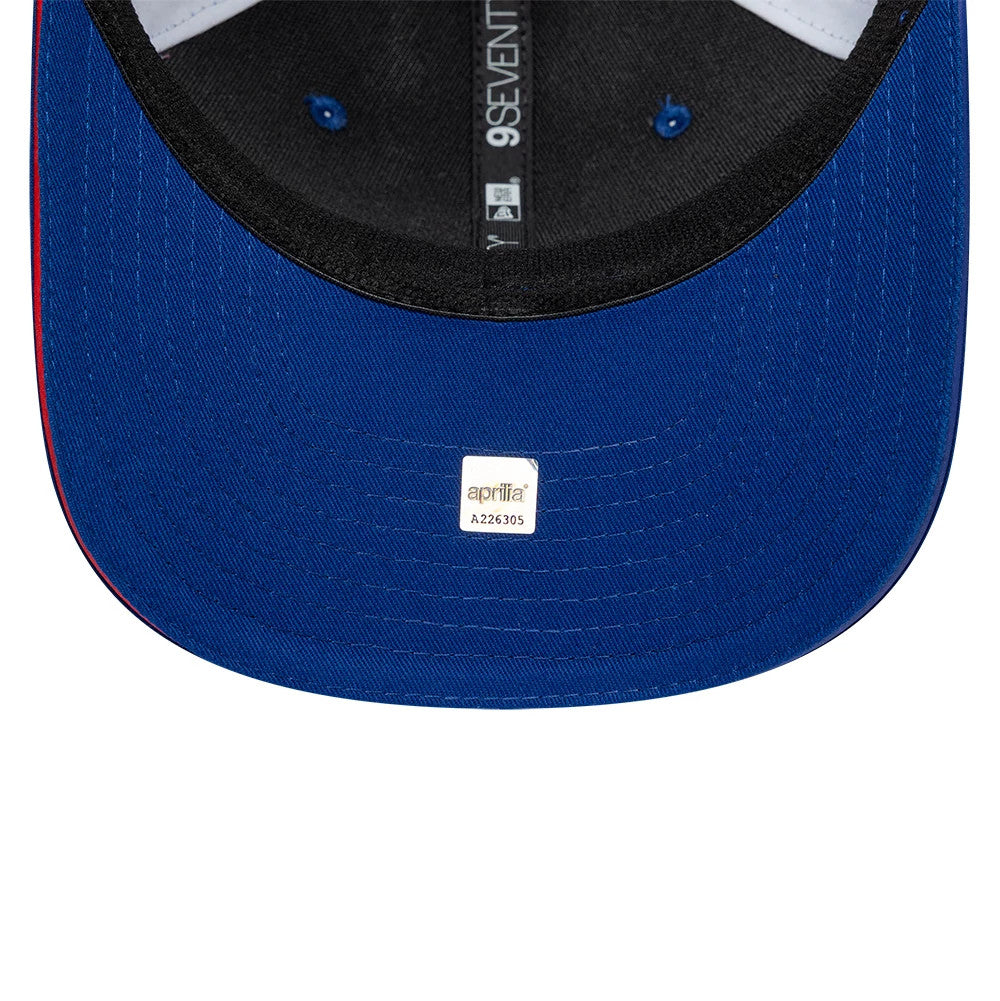Aprilia Replica Le Mans Race Special Blue New Era 9SEVENTY Stretch Snap Adjustable Cap, inside view showing a grey sweatband with white brand taping, a blue undervisor, and the aprilia sticker centred below the structured crown.