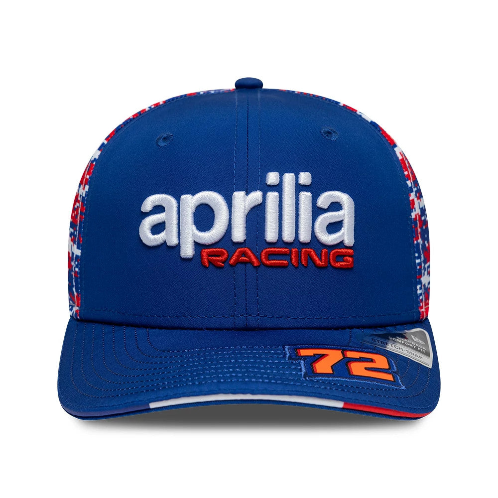 Aprilia Replica Marco Bezzecchi Le Mans Race Special Blue New Era 9SEVENTY Stretch Snap Adjustable Cap, front view showing the white aprilia logo with red racing text, a patterned red and white side panel, and orange 72 number on the blue visor.