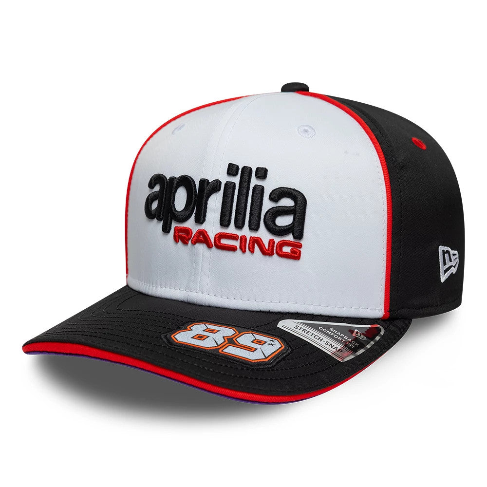 Aprilia Replica Jorge Martin White New Era 9SEVENTY Stretch Snap Adjustable Cap, three-quarter view showing black and red embroidered aprilia racing logo on the white front panel, black visor with number 89 and 9SEVENTY size sticker.