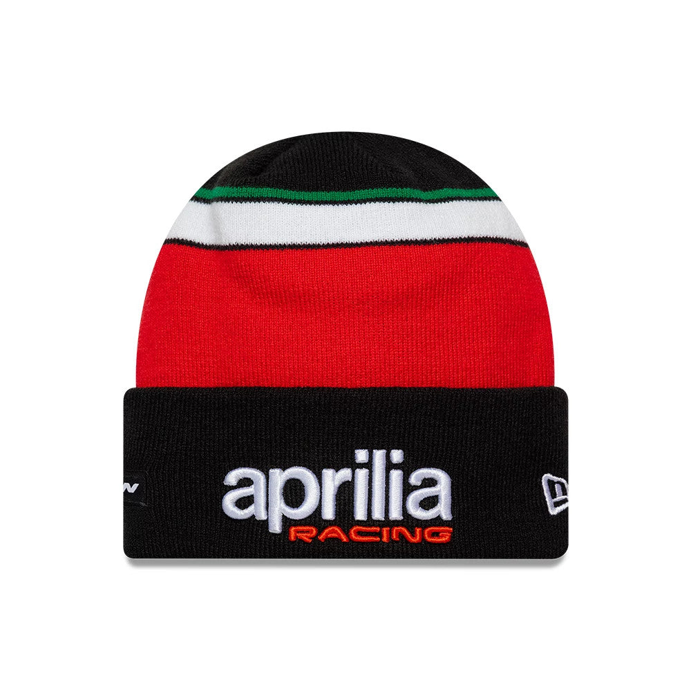 New Era Aprilia Team Black Cuff Knit Beanie Hat, front view showing white 'aprilia' embroidery with red 'RACING' below on the black cuff, a stripe pattern in green, white and red around the crown, and a New Era flag logo on the left side.