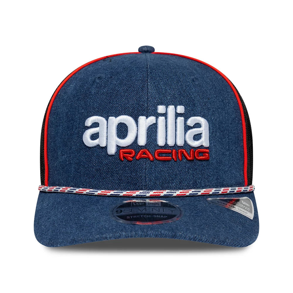 Aprilia Replica Austin Race Special Blue New Era 9SEVENTY Stretch Snap Adjustable Cap, front view showing white embroidered aprilia logo above red racing script, with a black structured crown and red piping, and a 9SEVENTY size sticker on the visor.