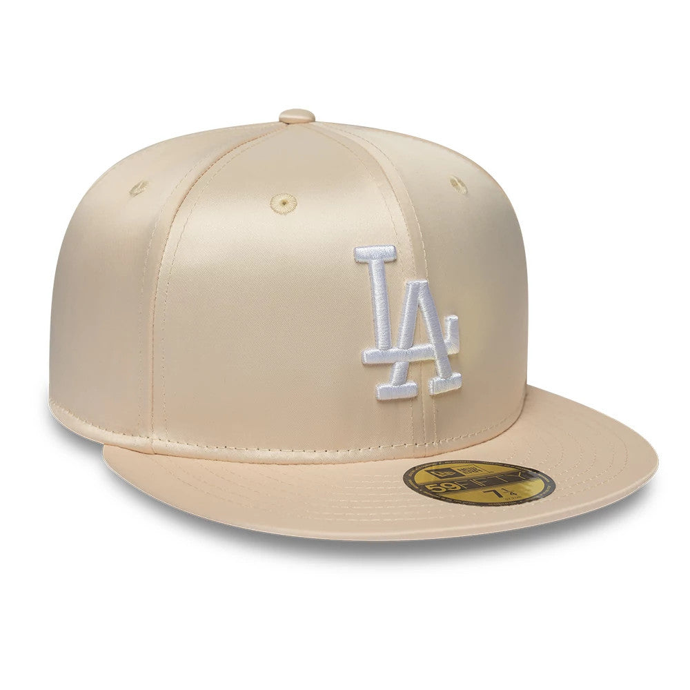 LA Dodgers MLB Satin Cream New Era 59FIFTY Fitted Cap, front view showing the white raised LA logo embroidered on the structured cream satin crown, with a matching cream visor and a gold 59FIFTY size sticker centred on the visor.
