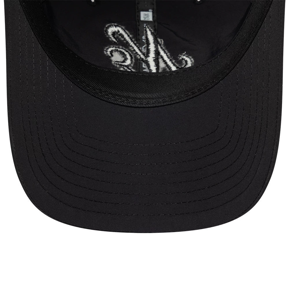 New Era Recycled Black On Black 9TWENTY Adjustable Cap, inside view showing the black undervisor with stitching details, white interior taping featuring an intricate pattern, and adjustable closure.
