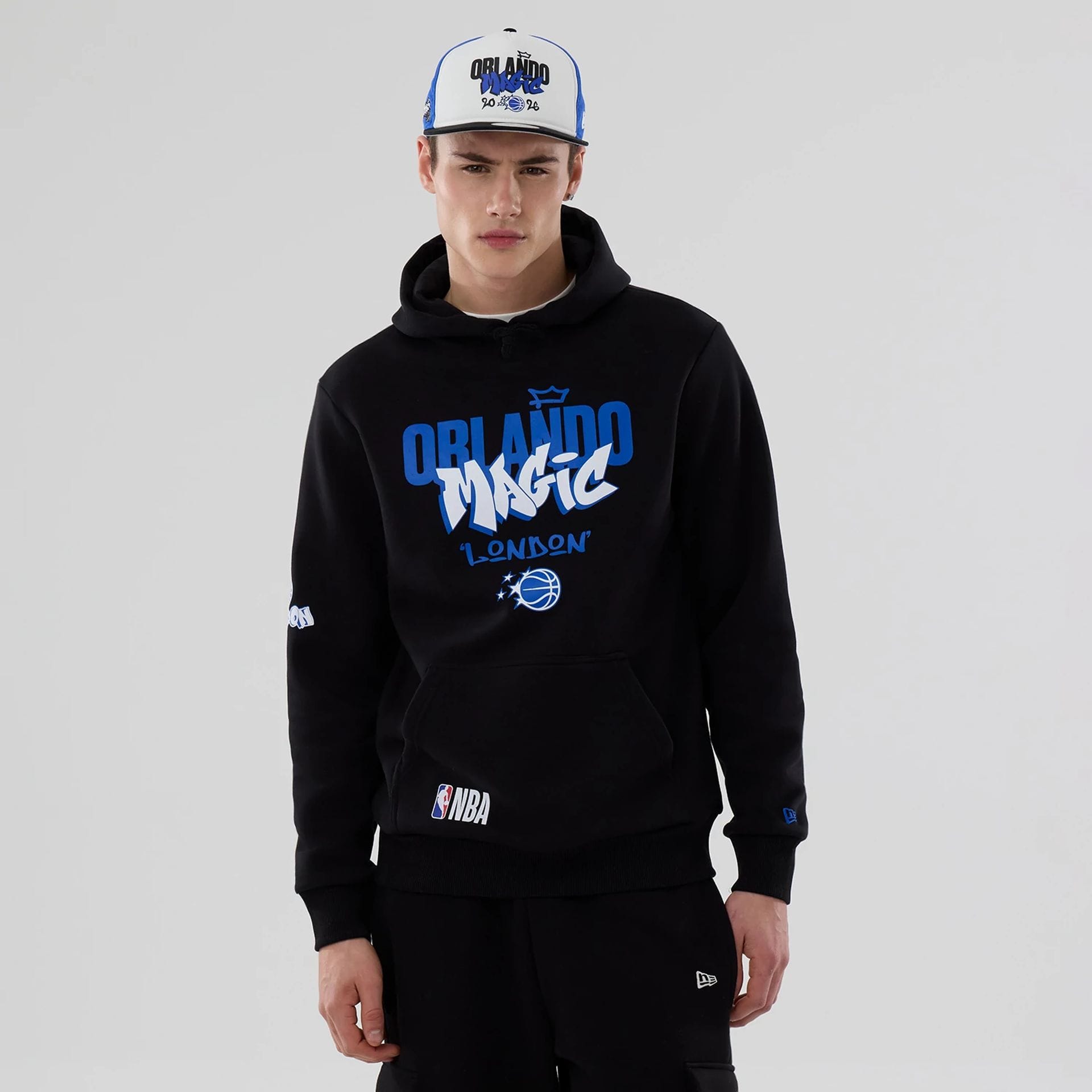 The model is wearing this NBA London Game 2026 Orlando Magic Pullover Hoodie in black. 1