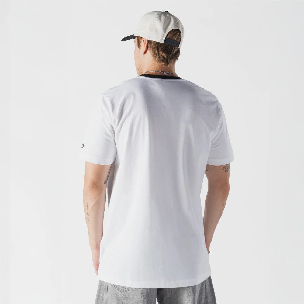 New Era Netflix Stranger Things Demogorgon White T-Shirt, back view on a model wearing a light-coloured cap and casual trousers, showing plain white fabric with a small embroidered logo on the right sleeve and a clean straight hemline.