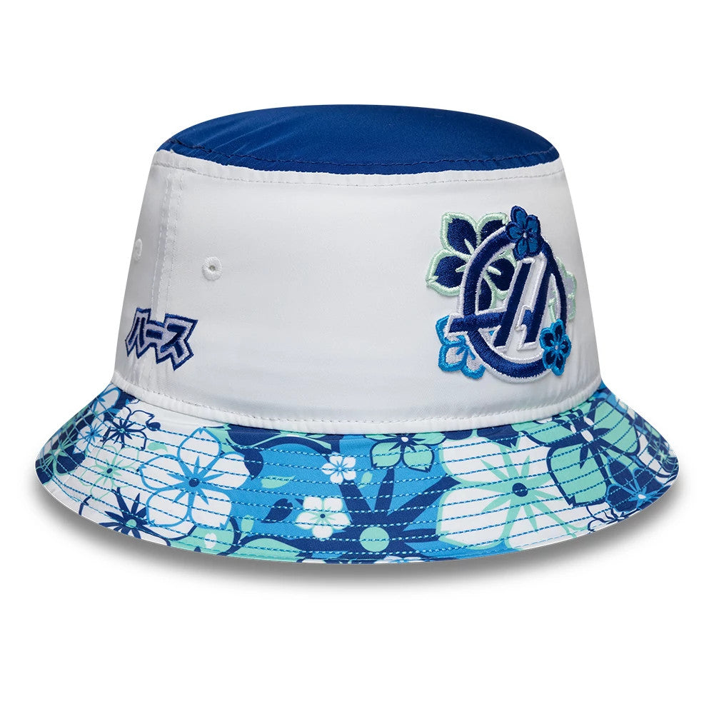 New Era TGR Haas F1 Japan Race Special White Bucket Hat, three-quarter view with a embroidered logo featuring blue and green flowers on the front panel, a floral patterned visor in shades of blue, and side embroidery detail in Japanese script.