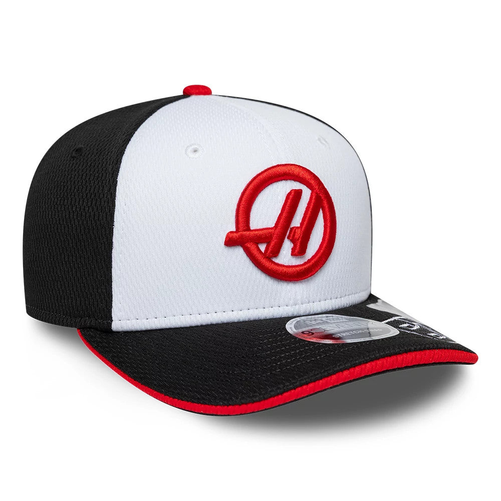 TGR Haas F1 Oliver Bearman Black New Era 9SEVENTY Stretch Snap Cap, three-quarter view showing the red embroidered logo on the white front panels, a black visor with red edging, and the 9SEVENTY size sticker on the top of the visor.