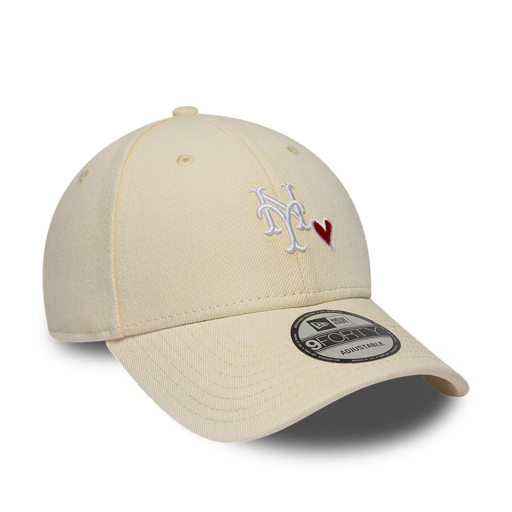 New York Mets MLB Washed Denim Light Beige New Era 9FORTY Adjustable Cap, three-quarter view showing a white embroidered NY logo with a red heart on the front panel, a pre-curved visor, and a 9FORTY size sticker on the light beige fabric.