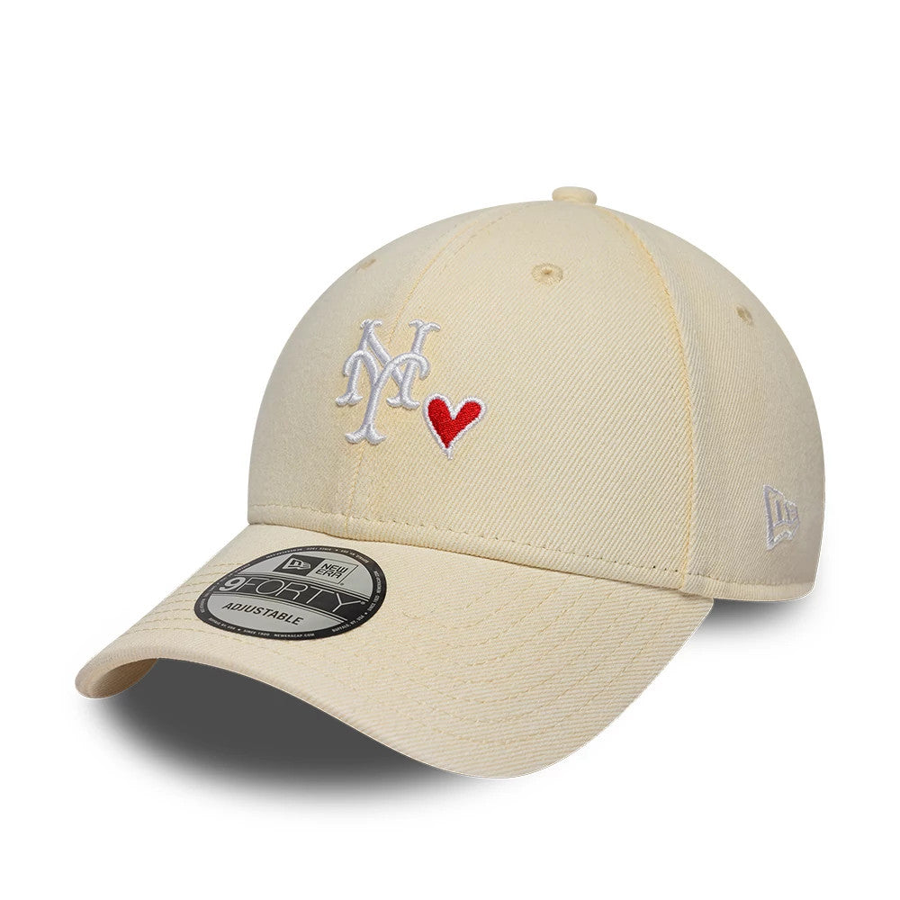 New York Mets MLB Washed Denim Light Beige New Era 9FORTY Adjustable Cap, three-quarter view showing the white embroidered NY logo and red heart on the front panel, curved light beige visor, and New Era flag on the left side.