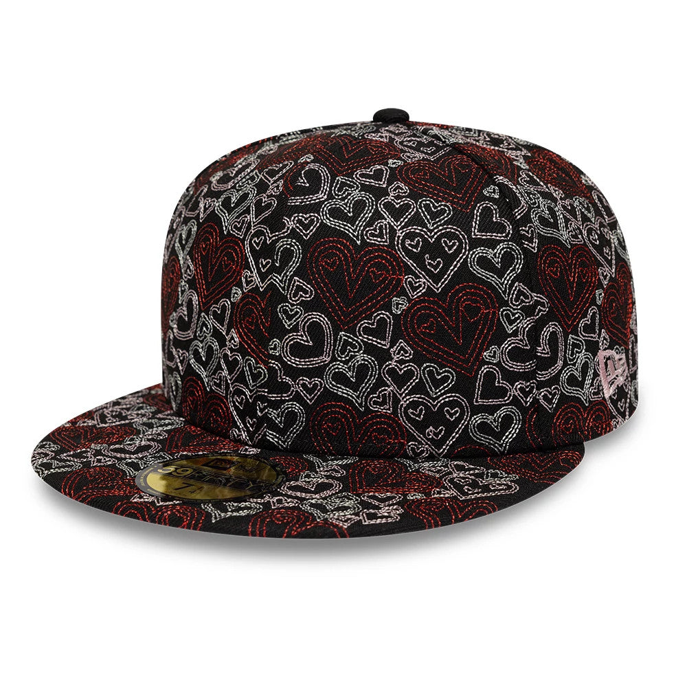 New Era All Over Hearts Black 59FIFTY Fitted Cap, front view showing a textured pattern of red and white embroidered hearts across the black structured crown and flat visor, with a gold 59FIFTY size sticker.