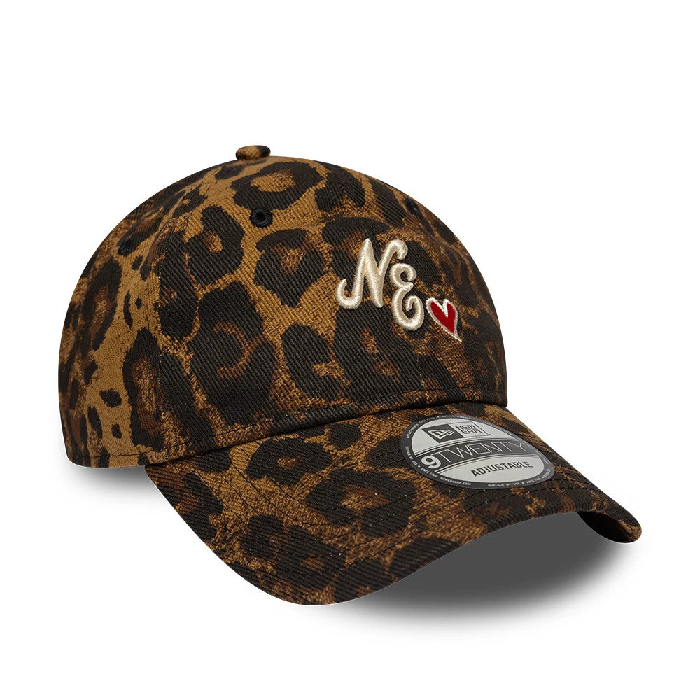 New Era Leopard Heart Brown 9TWENTY Adjustable Cap, three-quarter view showing the cream embroidered NE initials with a red heart on the front panel, a black leopard print pattern across the structured crown and curved visor.