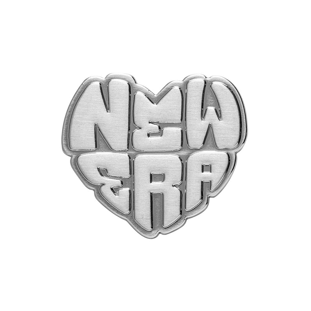 New Era Heart Silver Pin Badge, front view showing a heart-shaped silver badge with the raised lettering of NEW ERA across the centre, each letter uniquely shaped to fit snugly within the heart outline.