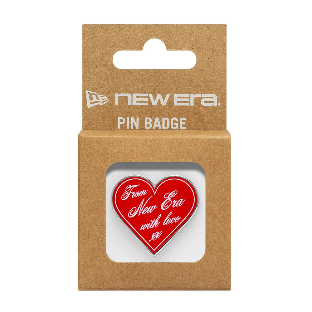 New Era Heart Script Red Pin Badge, front view displaying a heart-shaped badge with red colour, featuring the script From New Era with love xx in white, packaged in a cardboard display backing with the New Era logo printed on top.