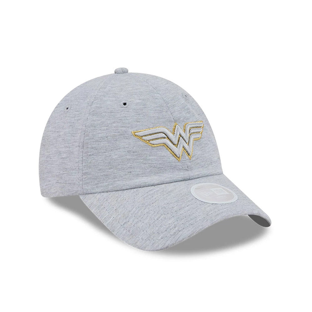 New Era Womens DC Wonder Woman Grey Open Back Cap, three-quarter view showing a gold embroidered Wonder Woman logo on the front panel, a slightly curved grey visor with a 9FORTY size sticker, and matching grey top button and eyelets.