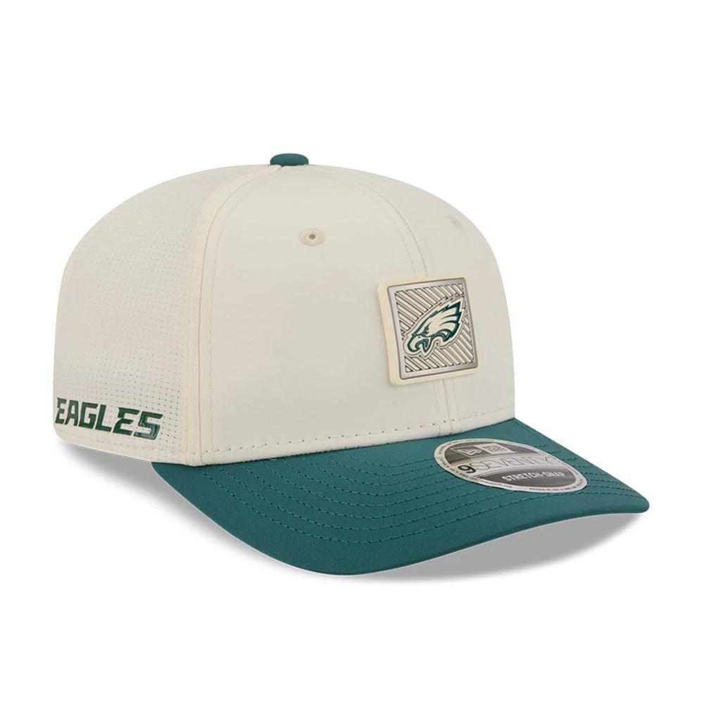 Eagles NFL Training 2026 White New Era 9SEVENTY Stretch Snap Adjustable Cap, three-quarter view showing a raised embroidered Eagles logo patch on the front panel, a contrasting teal visor with a 9SEVENTY size sticker.