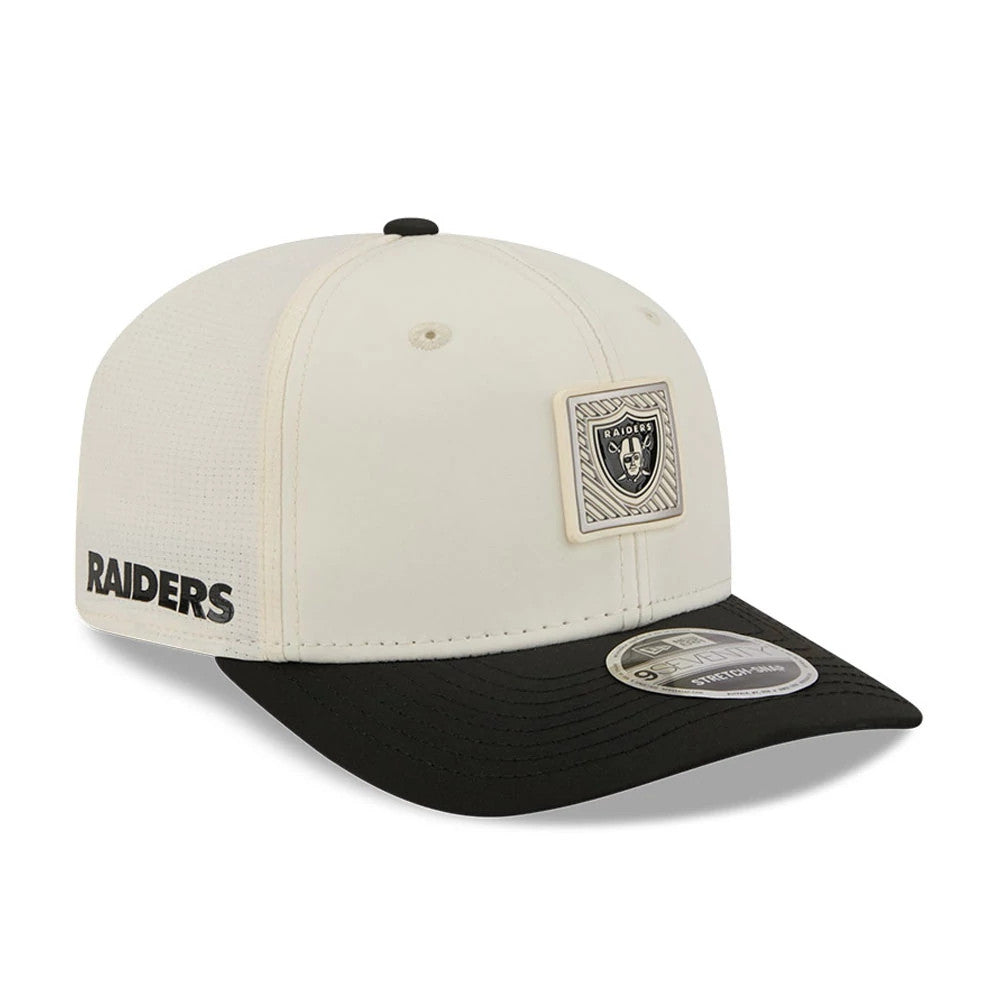 Raiders NFL Training 2026 White New Era 9SEVENTY Stretch Snap Adjustable Cap, three-quarter view showing a raised Raiders logo patch on the front, a black curved visor with a 9SEVENTY size sticker, and Raiders lettering on the left side.